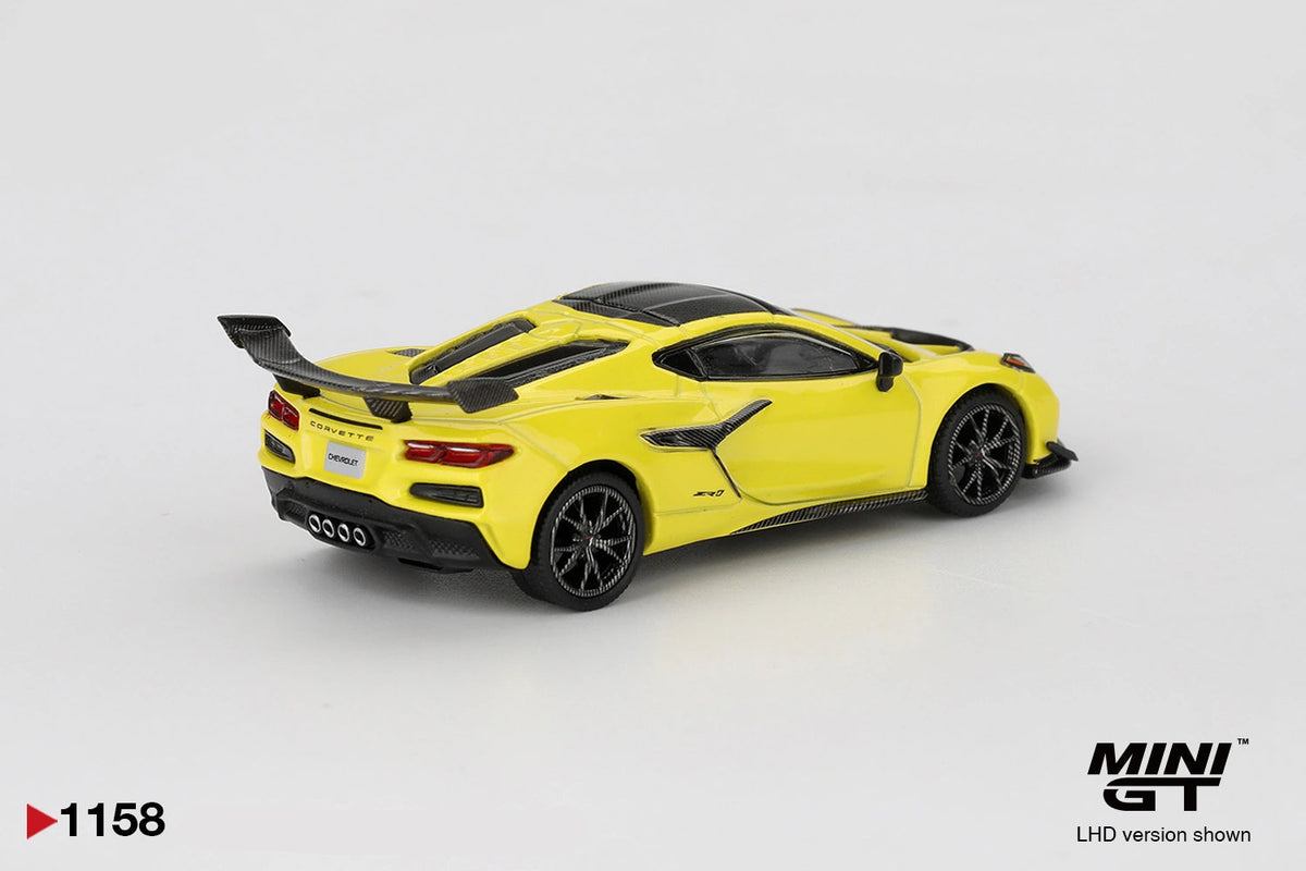 Rear three quarter view of Mini GT Chevrolet Corvette ZR1 Accelerate Yellow LHD showing the large black rear wing, Corvette lettering, four central exhaust outlets, black diffuser and rear lights.