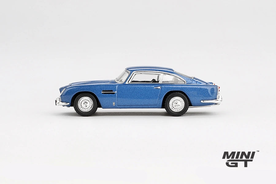 Mini GT Aston Martin DB5 Sierra Blue side profile showing the metallic blue body, chrome trim and wire-style wheels, LHD prototype shown