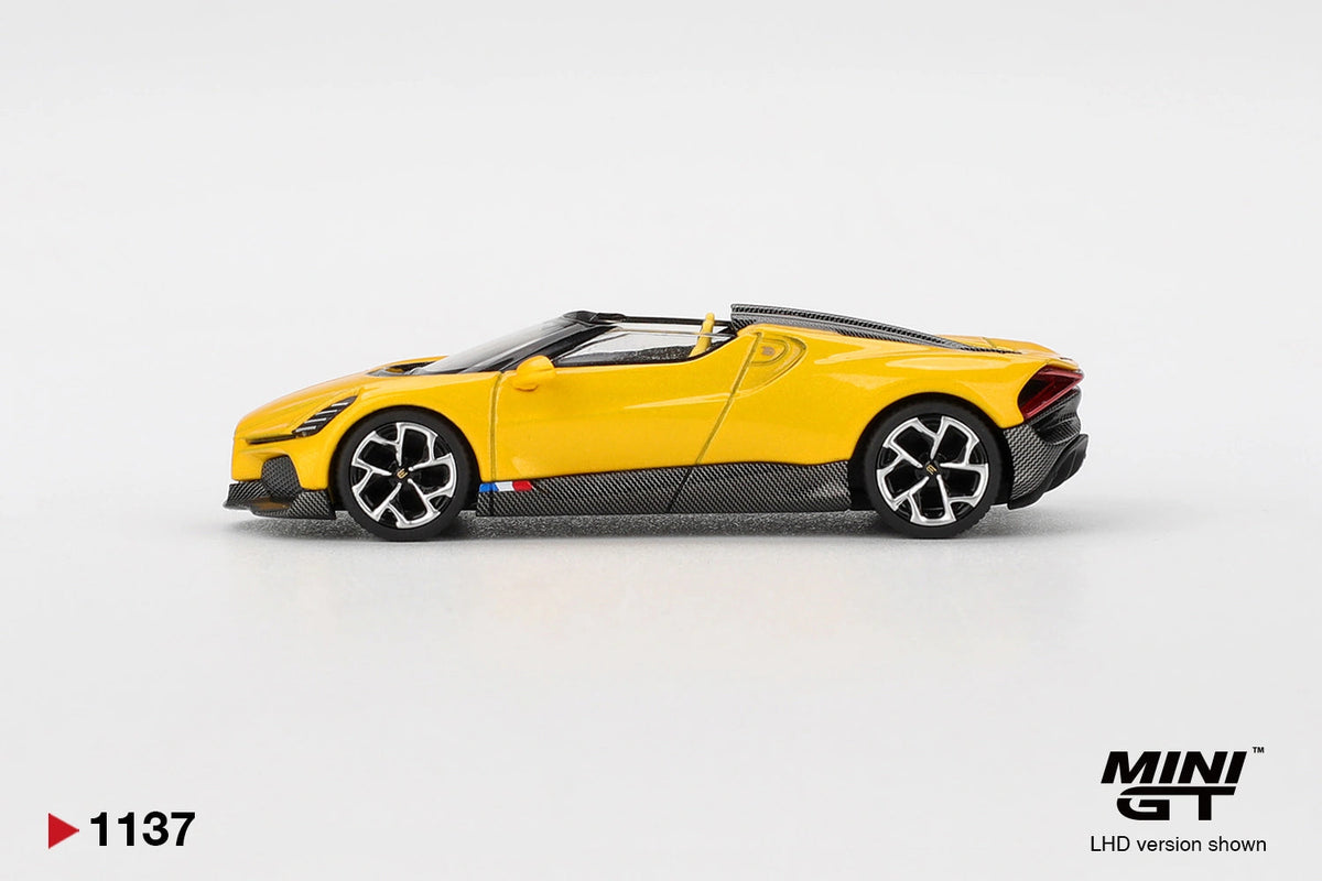 Side profile of Mini GT Bugatti W16 Mistral Yellow LHD showing the yellow roadster body, black lower panels, silver and black wheels and rear air intake