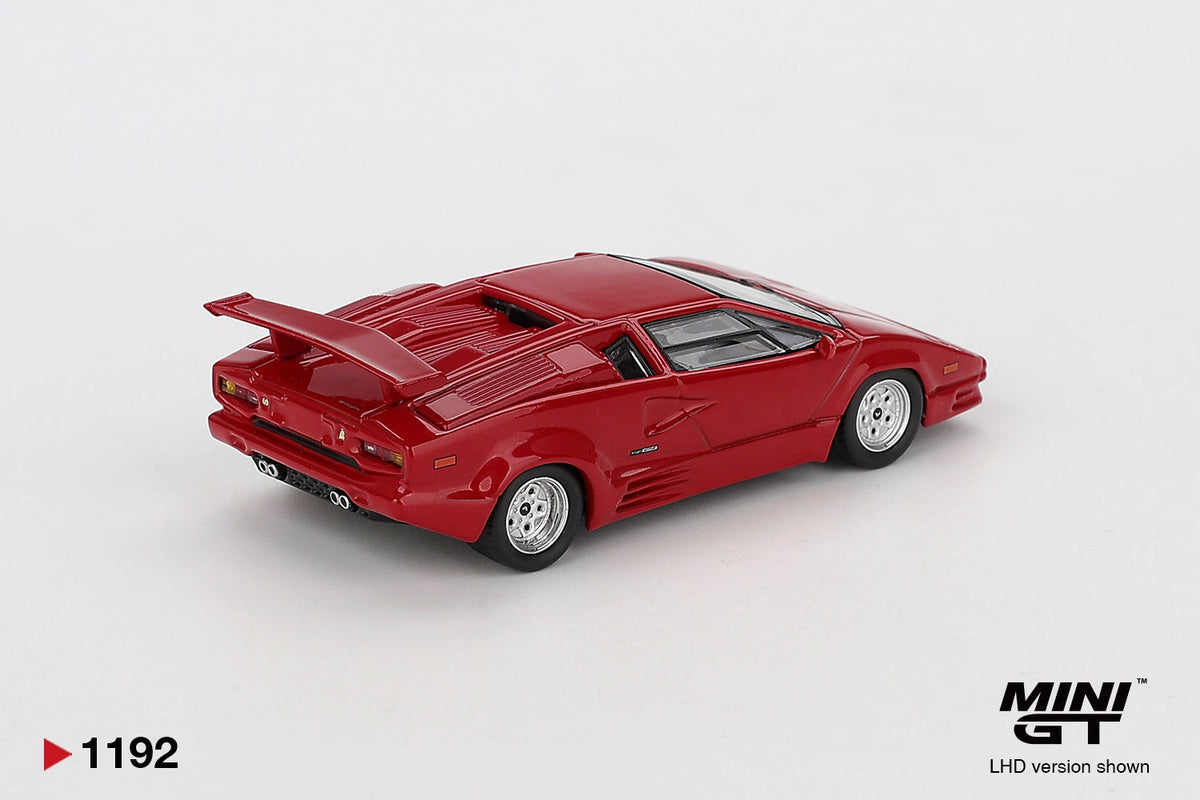 Rear three-quarter view of Mini GT Lamborghini Countach 25th Anniversary Red LHD showing the large rear wing, louvred engine cover, rear lights, quad exhaust pipes and silver wheels.