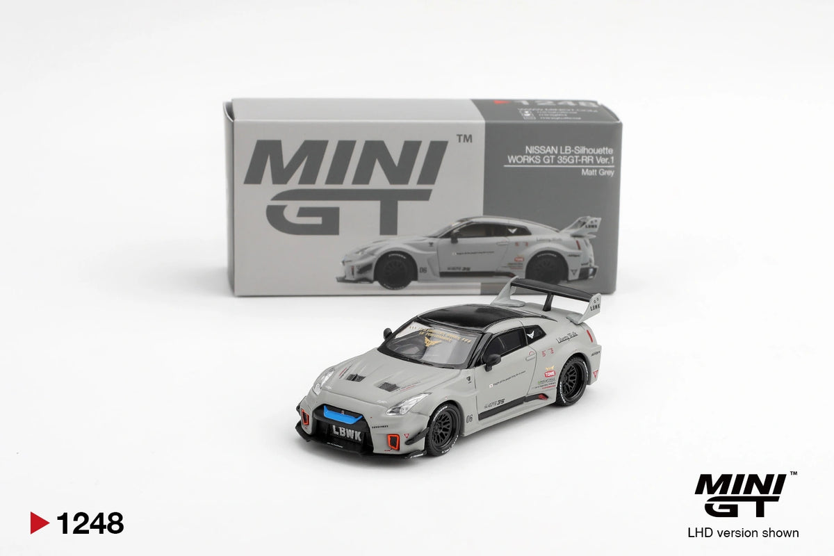 Mini GT Nissan LB-Silhouette WORKS GT 35GT-RR Ver.1 Matt Grey displayed with its collector box, showing black racing wheels, blue front grille accent, widebody styling and large rear wing. Promotional image labelled LHD version shown.