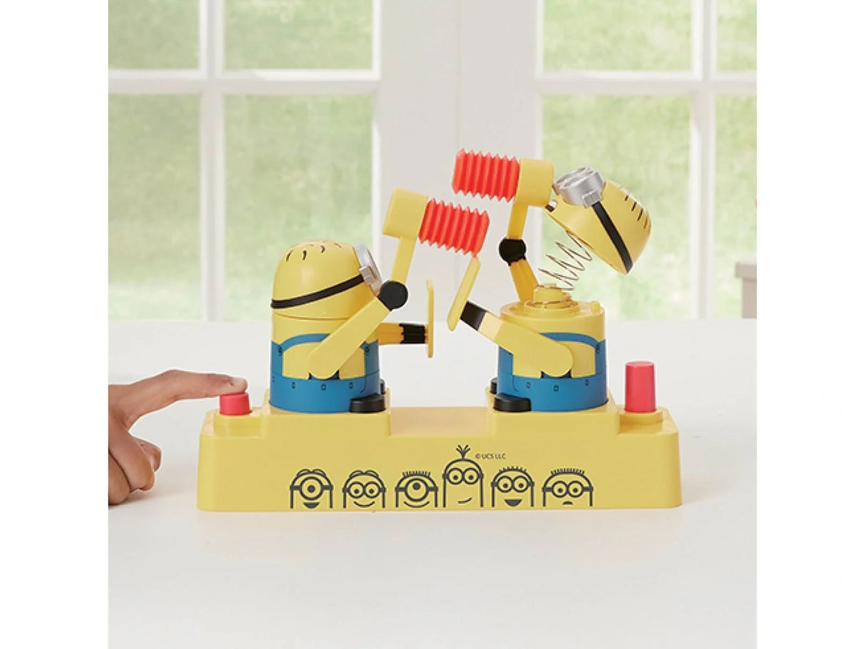 Hand pressing the red button on the left side of the Minions Hammer POP game