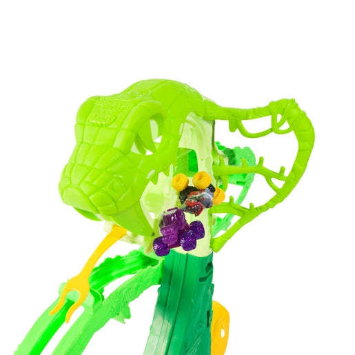 Two Monster Jam Mini Jams trucks inside the green cobra head section of the playset