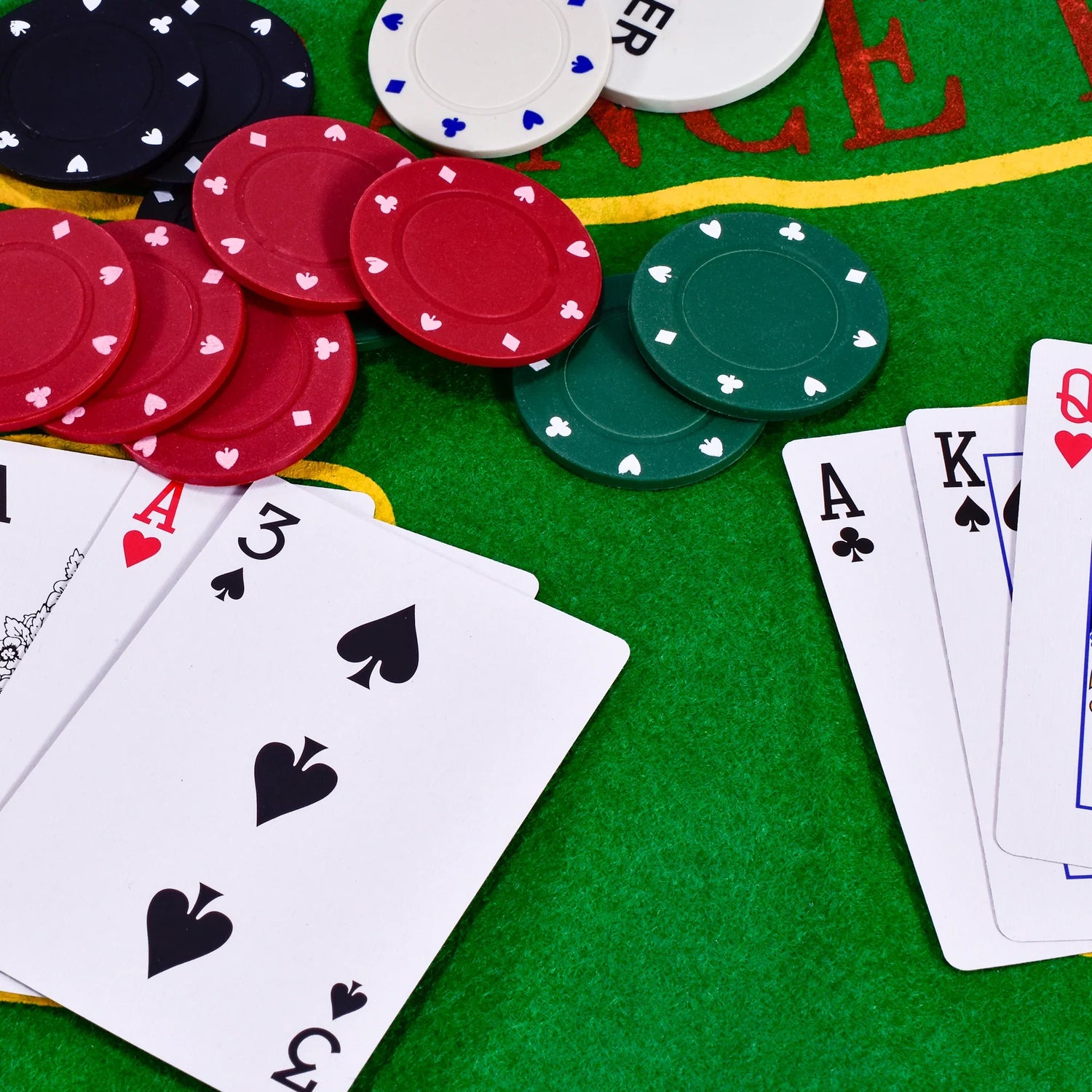 Close-up of M.Y poker chips and playing cards on green felt mat Ireland