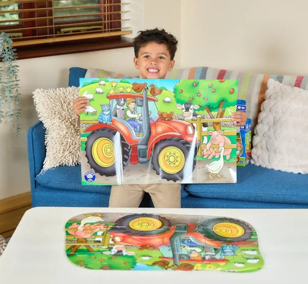 Child holding completed Orchard Toys Big Tractor puzzle in Ireland