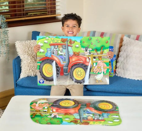 Child holding completed Orchard Toys Big Tractor puzzle in Ireland