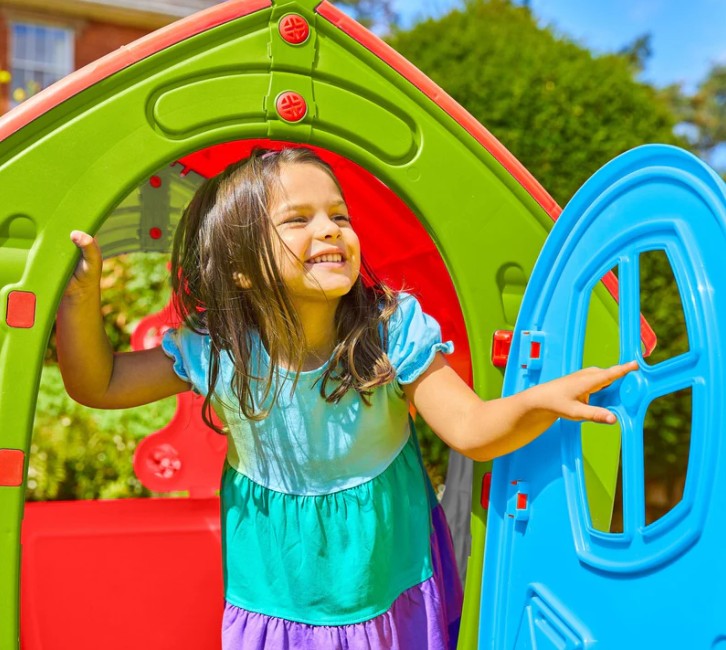 Girl opening front door of Palplay Dream House Playhouse Red Green Blue - Ireland