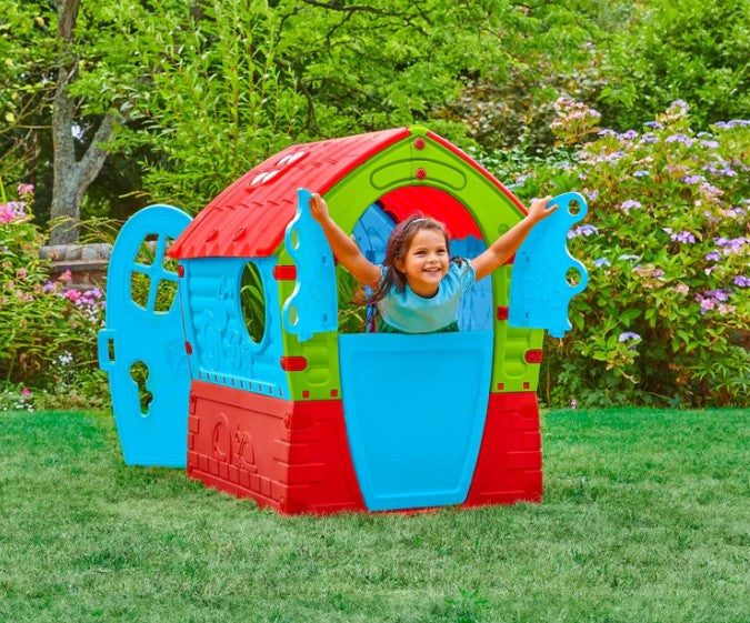 Girl peeking through side window of Palplay Dream House Playhouse - Ireland Caption: Smiling child enjoying playtime through the window