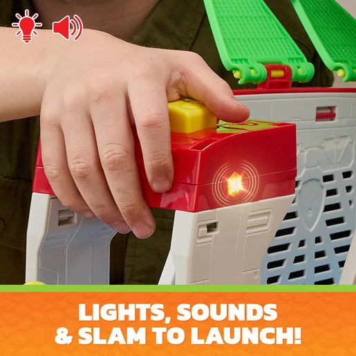 Hand pressing the yellow button on the PAW Patrol Dino Mobile Headquarters with the red light illuminated