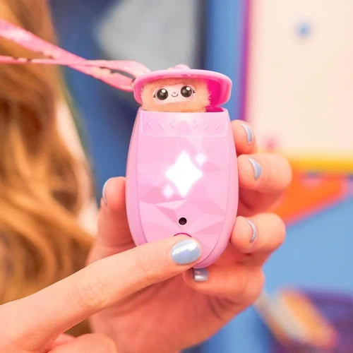 Close-up of a hand holding the pink Peekimo interactive pet with its fluffy face visible above the pod, illuminated white star shapes and a finger pressing the circular button.