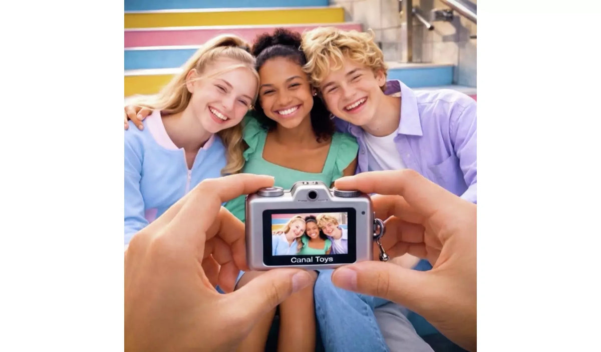 Hands holding a silver Photo Creator Mini Cam with three people shown on the screen