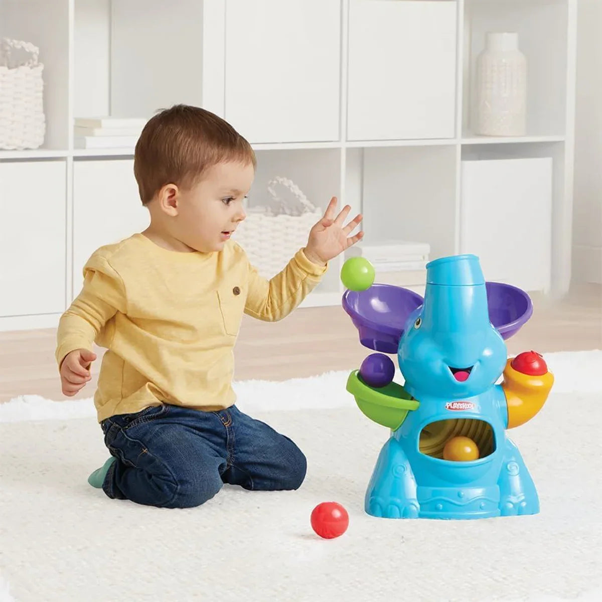 Toddler playing with PlaySkool Elefun Busy Ball Popper toy on the floor in Ireland
