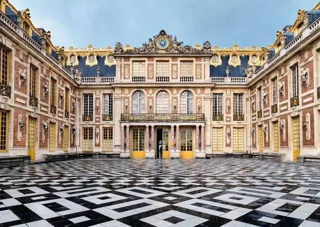Ravensburger Château de Versailles puzzle artwork showing the palace courtyard with ornate façades and black and white geometric paving