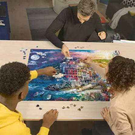 Ravensburger Colourful Cinque Terre 2000 piece jigsaw puzzle in progress on a table with people placing pieces