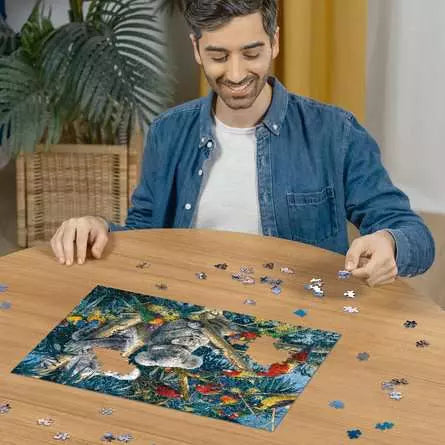 Person building the Koalas in a Tree puzzle on a round wooden table