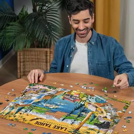 Man building the Sacred Lake Tahoe jigsaw puzzle on a table