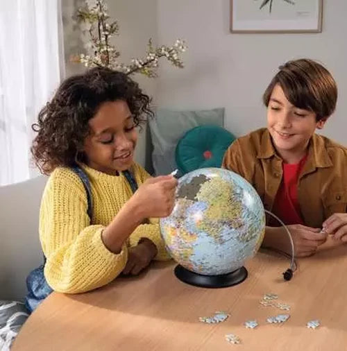 Ravensburger The World on V Stand globe puzzle shown in a warm toned indoor setting.