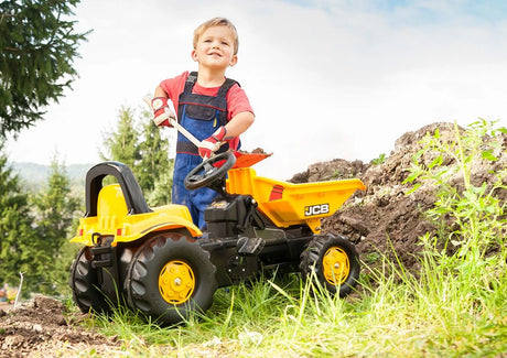 Child playing with RollyKid JCB Dumper outside on grass with shovel – Ireland