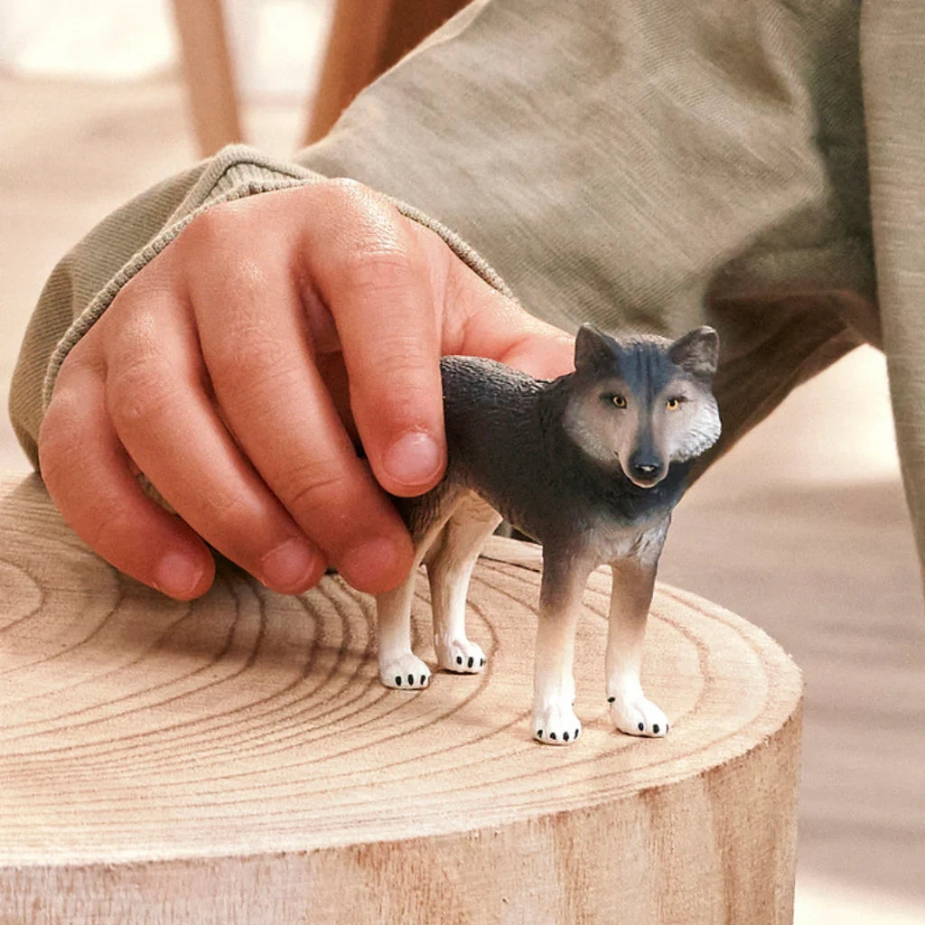 Schleich American Wolf figure held on a wooden surface
