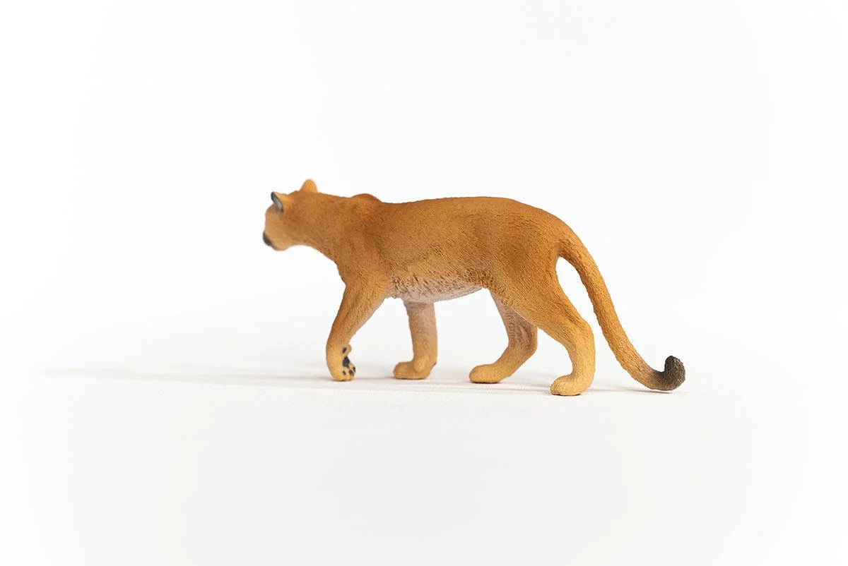 Schleich Cougar figure with a tan coat, pale belly, dark ear tips and a long curved tail with a dark tip.