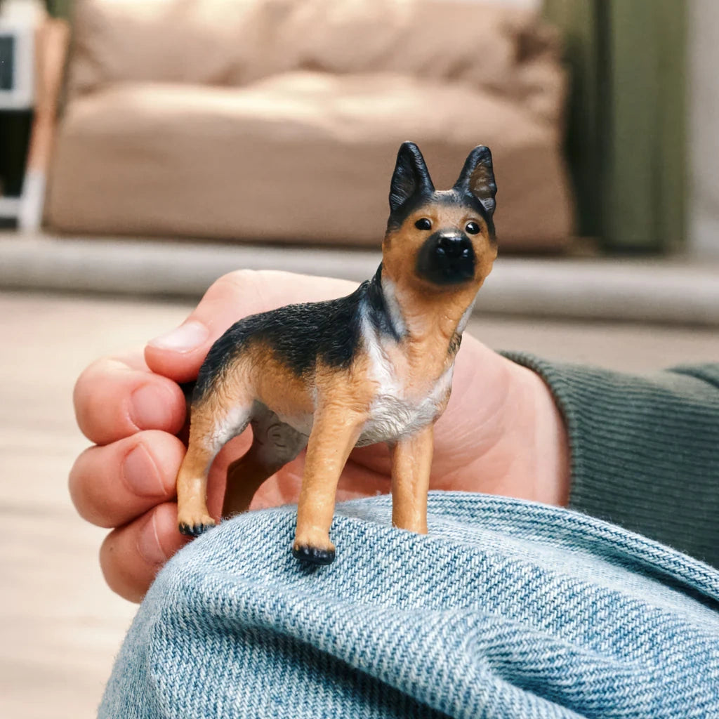 Schleich German Shepherd Female figure held in a hand indoors
