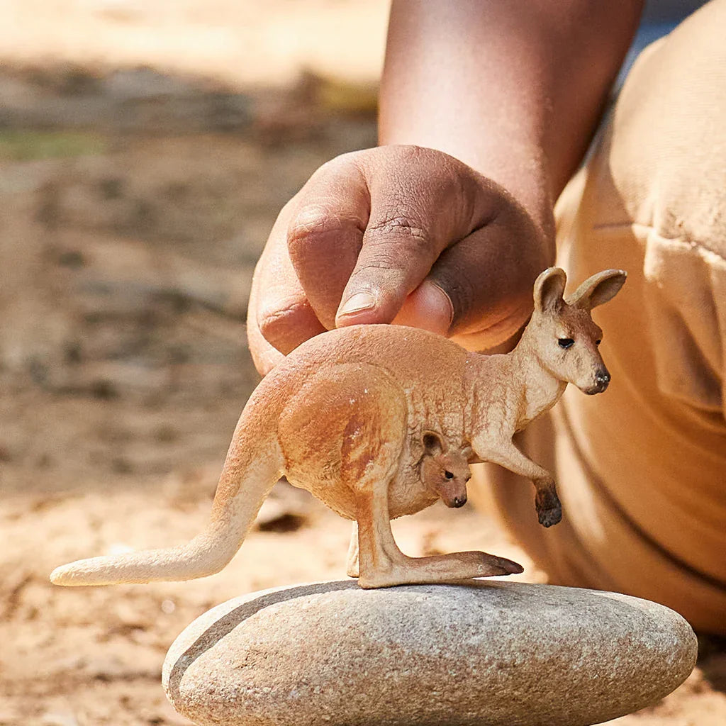 Schleich kangaroo figure being held during play, showing the joey in the pouch.