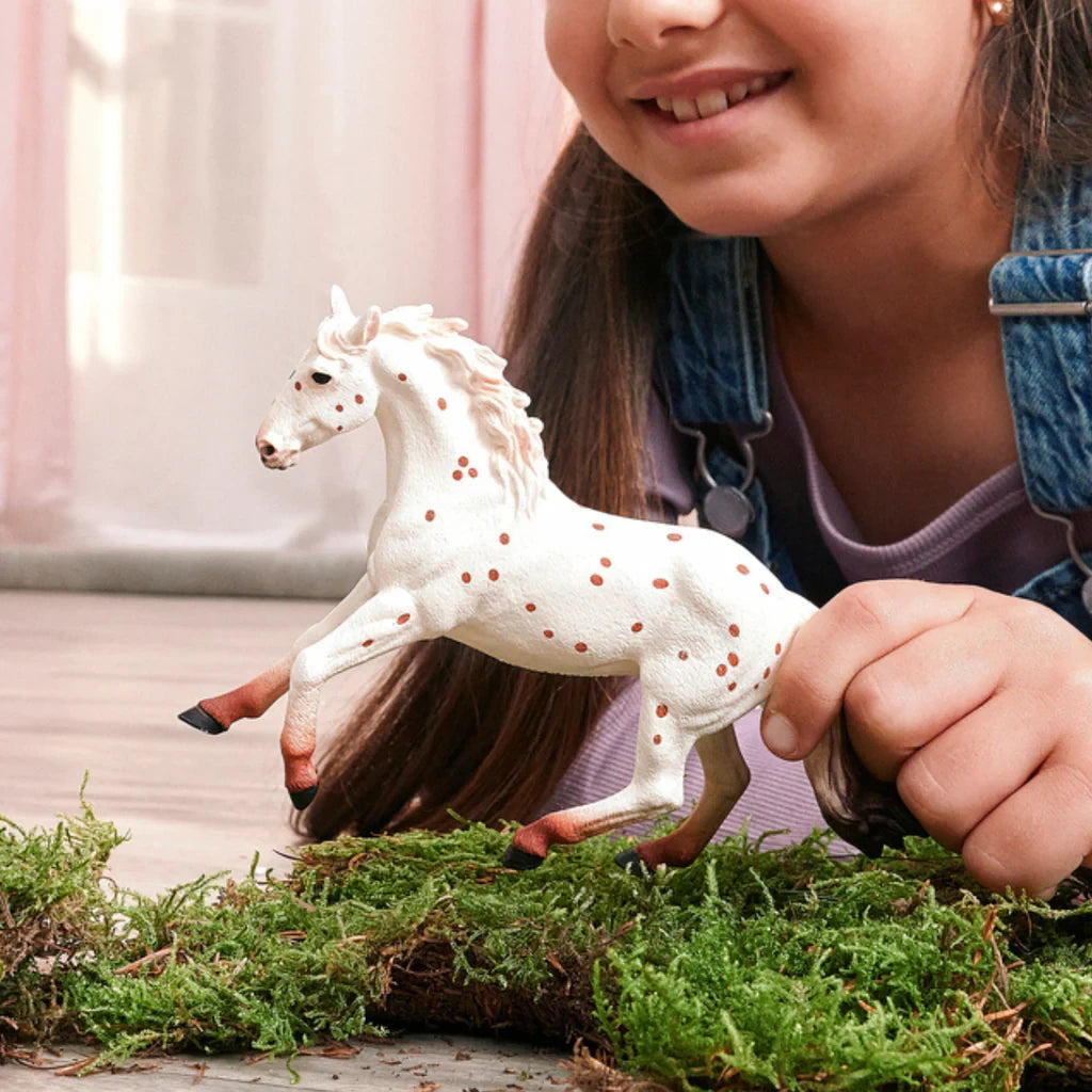 Schleich Knabstrupper Mare figure in a child play scene with grass