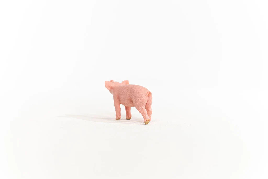 Schleich Piglet figure shown from behind with a curled tail and one rear leg extended.
