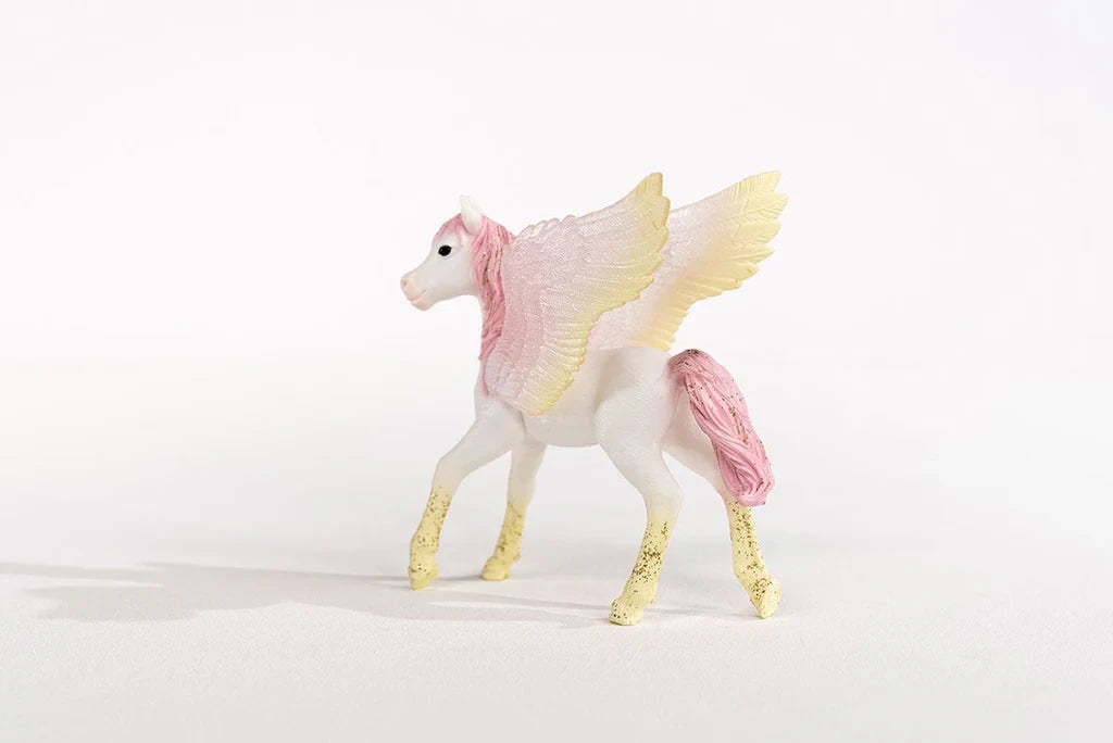 Schleich Sunrise Pegasus Foal figure shown from the left side with pink mane, yellow legs and raised pastel wings
