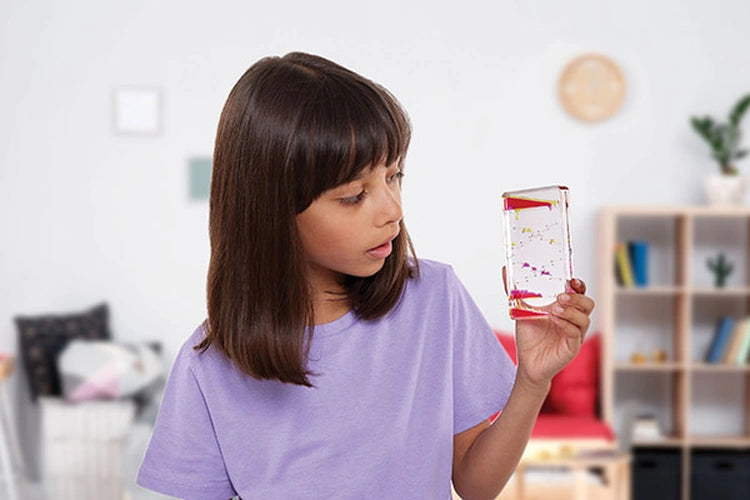 Girl wearing a purple T-shirt looking at a Sensory Motion Bubbler Stair with pink droplets inside