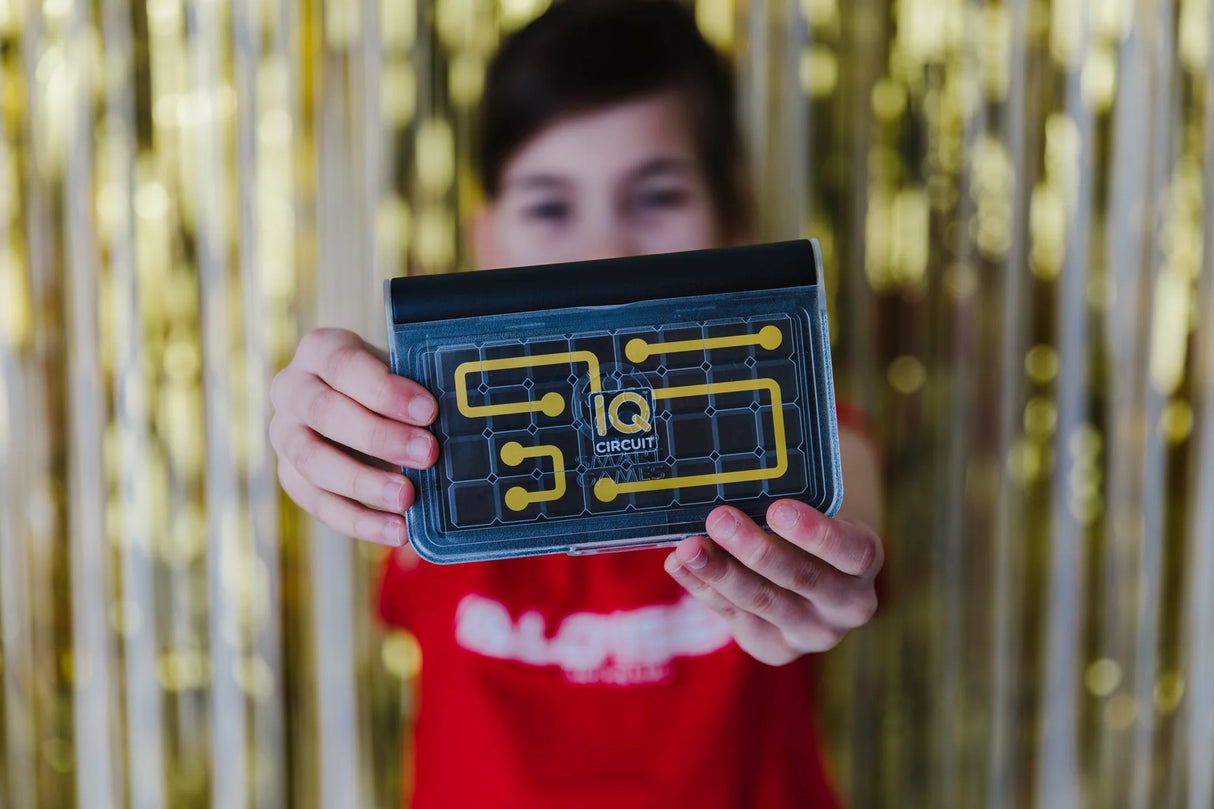 Child holding completed IQ Circuit puzzle with yellow circuit path – Ireland