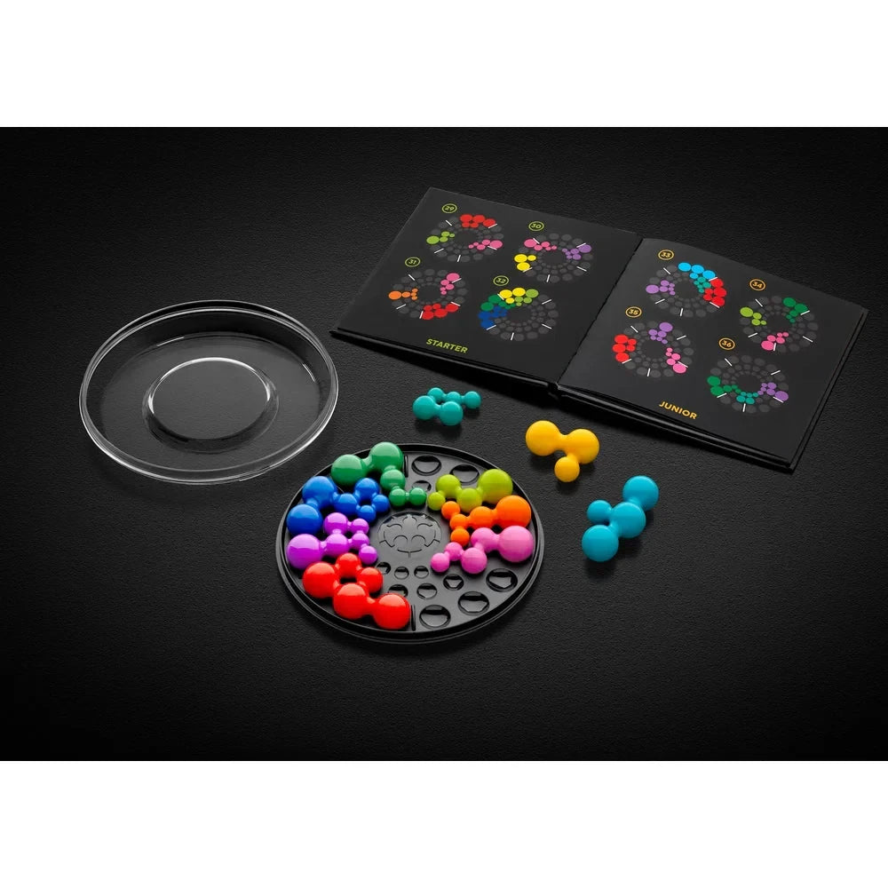 SmartGames IQ Circle board, clear lid, loose puzzle pieces and challenge booklet on a dark surface