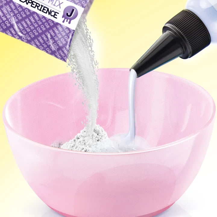White slime powder and liquid being poured from a purple sachet and nozzle bottle into a pink mixing bowl against a yellow background.