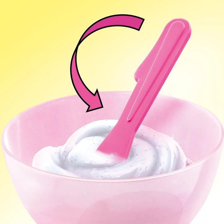Pink spatula stirring white slime in a pink mixing bowl, with a curved pink arrow indicating the mixing motion against a yellow background.