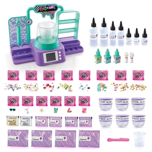 So Slime Experience Lab contents arranged on a white background, including the electronic laboratory, ingredient bottles, colour bottles, slime powder sachets, decorations, miniature charms, six labelled slime containers, measuring cup and pink spatula.