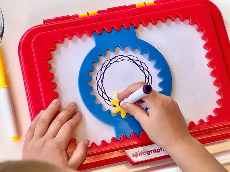 Child using Spirograph Jr. to draw a pattern with blue gear – Ireland