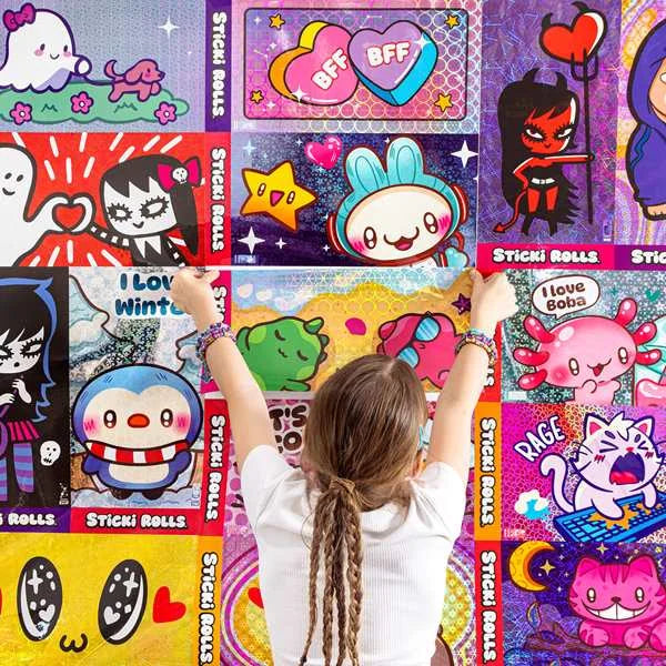 Child decorating a wall with colourful Sticki Rolls Jumbo Sticki posters featuring cute cartoon and holographic designs