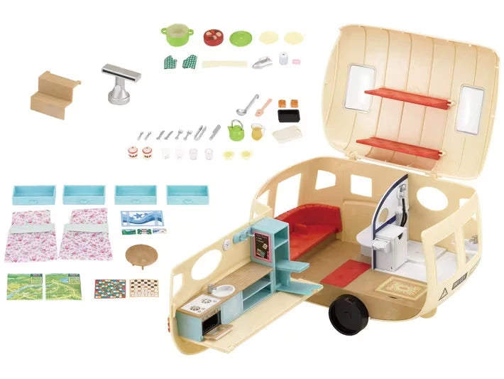 Open Sylvanian Families caravan shown with small furniture and accessories laid out on a white background