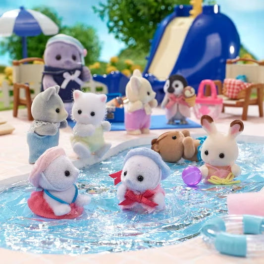 Two Sylvanian Families seal babies playing in a swimming pool with other animal figures, including rabbits and cats, beside a blue water slide and poolside furniture.