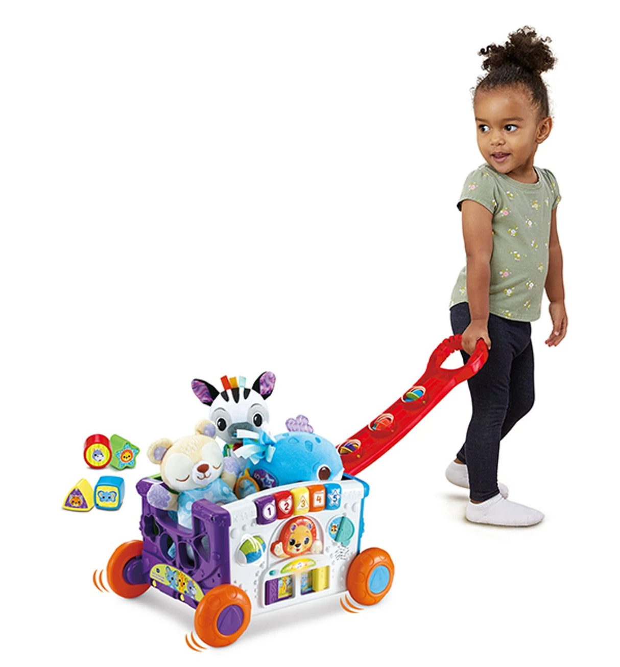 Toddler pulling VTech Sort & Discover Activity Wagon with toys inside and red handle extended