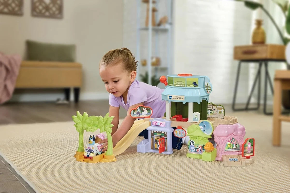 Child playing with the VTech Bluey Ice Cream Adventure Play Set and Ice Cream Truck on a rug