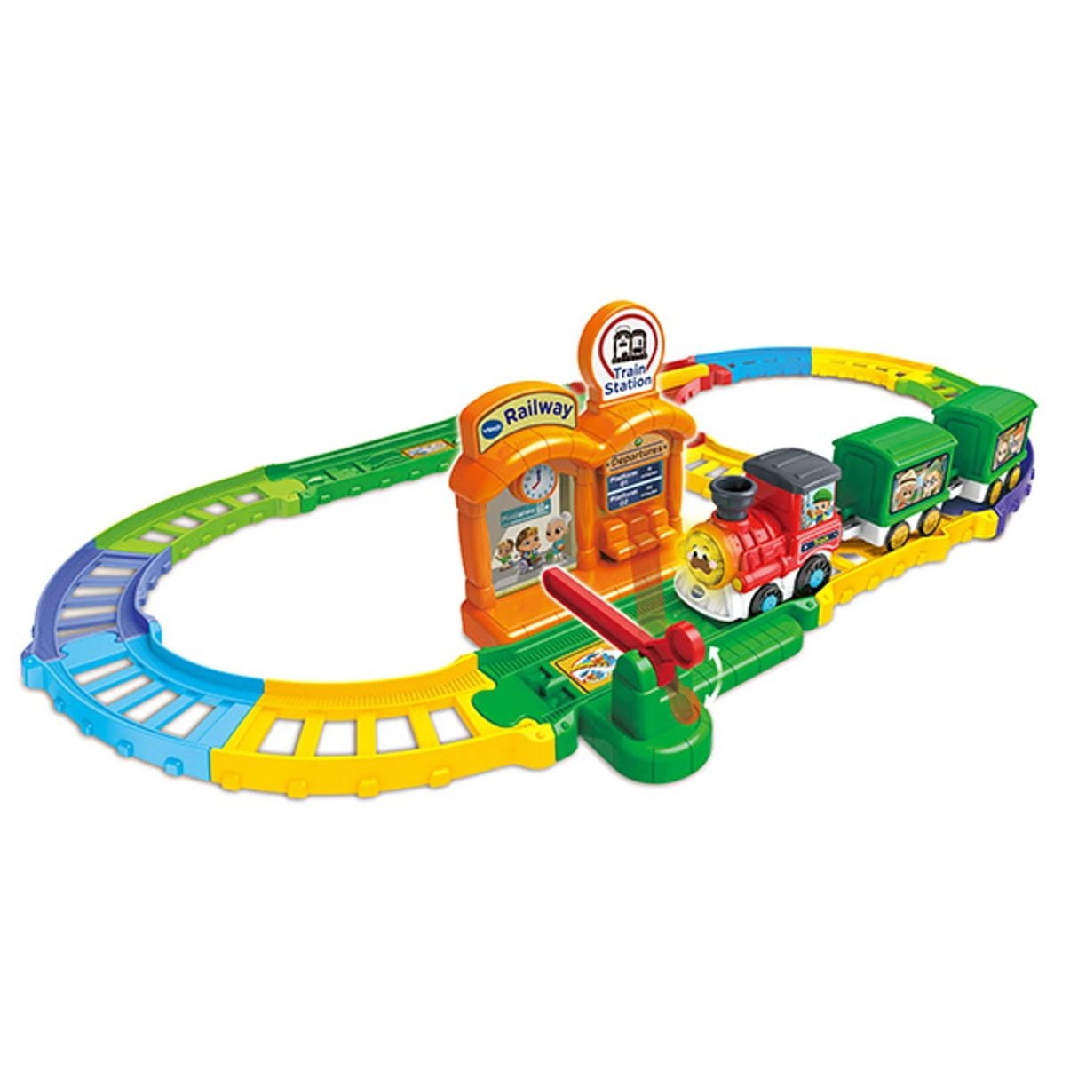 Assembled Chug & Learn Train Set track with colourful oval layout, orange station piece, green and yellow track segments, red train engine with two green wagons, and station gate lever.