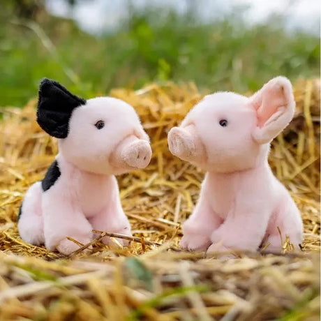 Two Animigos World of Nature piglet plush toys sitting on straw
