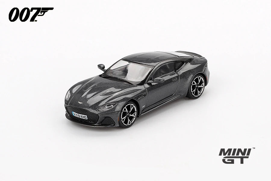 Mini GT James Bond No Time To Die Aston Martin DBS grey RHD prototype viewed from the front left showing the grille, bonnet vents, black roof and alloy wheels