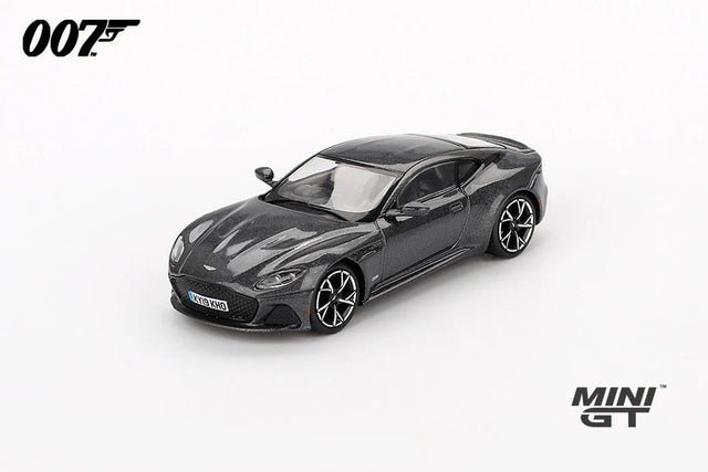 Mini GT James Bond No Time To Die Aston Martin DBS grey RHD prototype viewed from the front left showing the grille, bonnet vents, black roof and alloy wheels