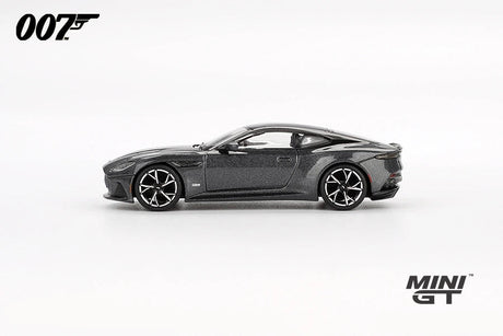 Grey Aston Martin DBS from No Time To Die in full right side profile showing the long bonnet, black roof panel, side vent and multi spoke wheels