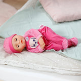 Baby Born Anna Pink 36cm lying on a bed with closed sleeping eyes in pink romper and hat