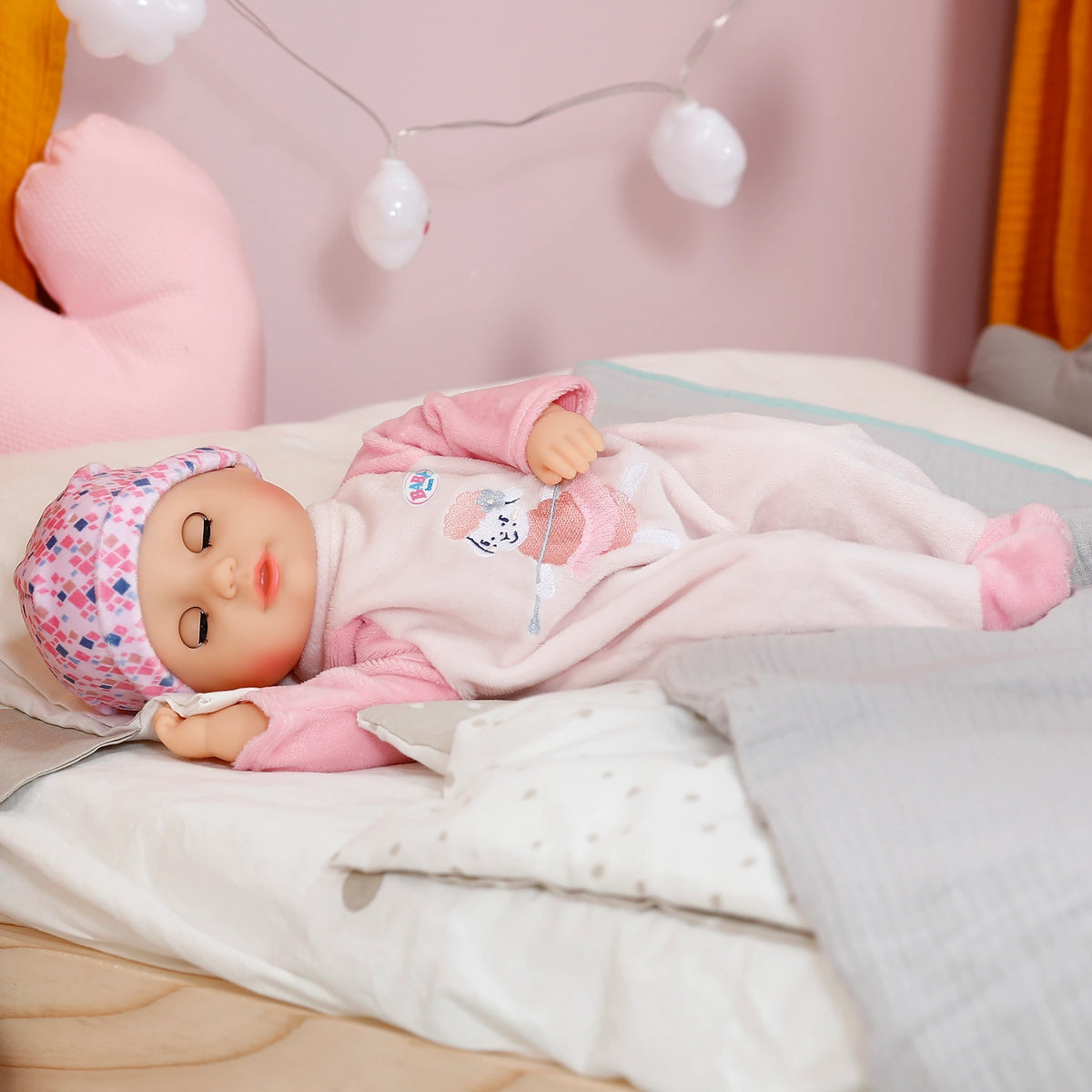 Baby Born Anna Rose doll lying on bed with eyes closed