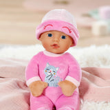 Baby Born For Babies Sleepy Pink doll seated on pink bedding with cat motif