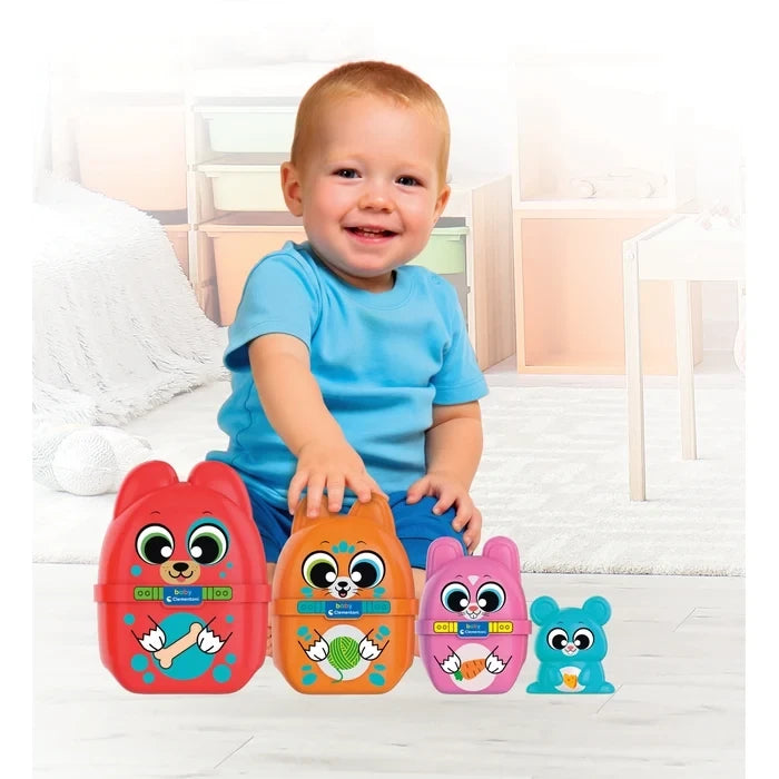 Smiling young child wearing a blue T-shirt playing with Baby Clementoni What's Inside? animal nesting toys, showing the red dog, orange cat, pink rabbit and blue mouse.
